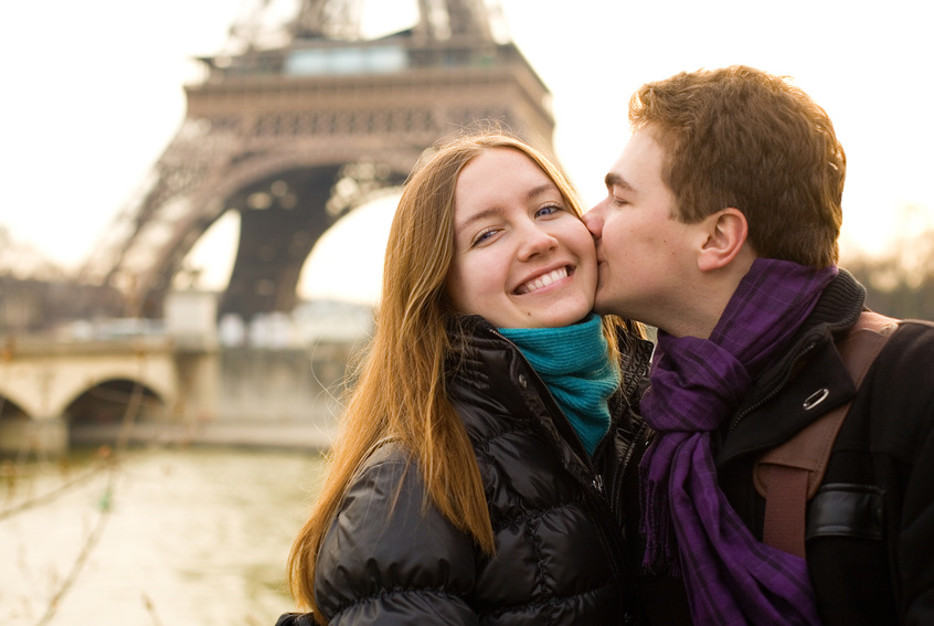 Happy loving couple in Paris, kissing by the Eiffel Tower